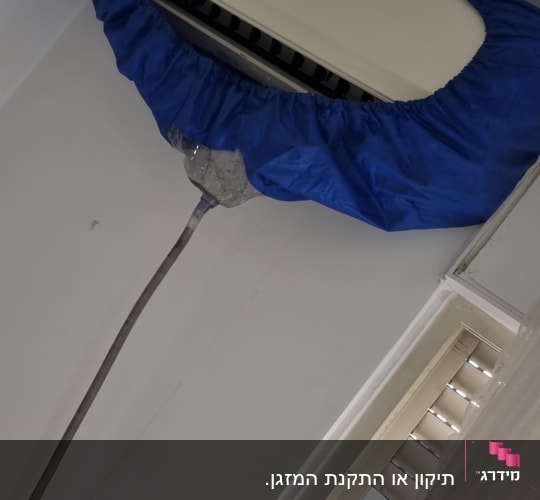 מזגן מכוסה בכיסוי כחול על הקיר